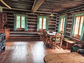 Ein rustikales Blockhaus-Interieur mit einem Holzespeisetisch, Stühlen und einer Bank.