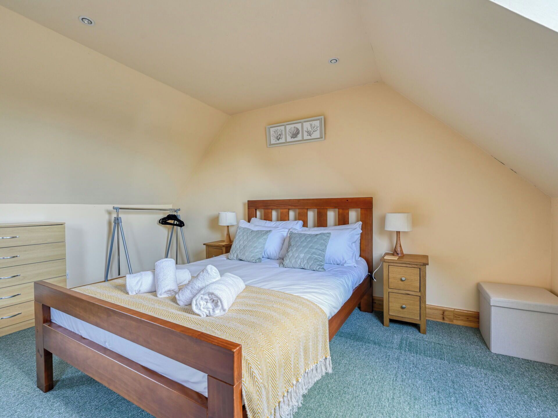 A bedroom with a wooden bed, two bedside tables, a nightstand, a dresser, and a radiator.