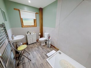 Een badkamer met toilet, wastafel en douchehoek.