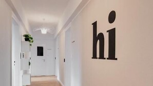 A hallway with a wooden floor, white walls, and a ceiling light fixture. - Saniertes Altbauzimmer an der Karlsaue (Kassel)