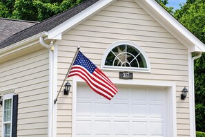 A house with a garage door, an American flag, and a mailbox.