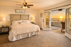 A bedroom with a bed, two bedside tables, a ceiling fan, and a view of the beach through a sliding door. - Stunning Sunset Views,Great for Families W Parking! (Newport Beach)