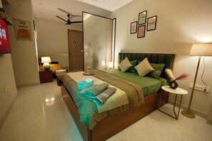A bedroom with a bed, bedside tables, a mirror, and a ceiling fan. - Cozy 1-bedroom apartment on golf course roadGurugram near Metro (Gurugram)