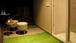Een kamer met een schuifdeur van glas, een klein tafeltje met kaarsen, en een luchtbevochtiger aan de muur.