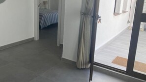 A room with a bed, a door, and a view of a balcony. - Lovely 1-Bedroom Apartment, Pueblo Evita (Benalmádena)