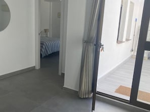 A room with a bed, a door, and a view of a balcony. - Lovely 1-Bedroom Apartment, Pueblo Evita (Benalmádena)