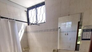 A bathroom with a toilet, sink, and shower area. - Gaia Rodadero (Santa Marta)