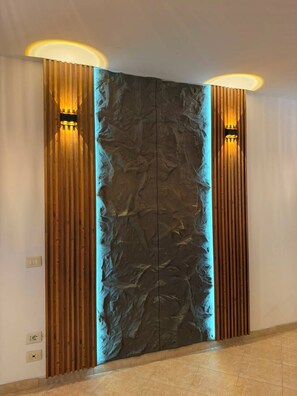 A modern interior with a textured wall and vertical wooden slats.