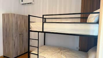 Un lit superposé avec un placard et un appareil de climatisation.