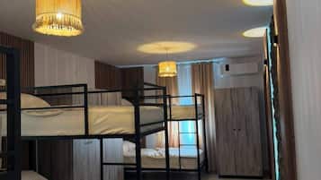 Una habitación con literas, un candelabro y una ventana con cortinas.