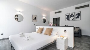 Une chambre d’hôtel moderne, dotée d’un grand lit, de tables de chevet et d’œuvres d’art accrochées aux murs.