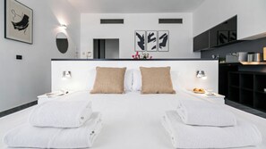 Ein modernes Hotelzimmer mit einem großen Bett, zwei Nachttischen, einem Spiegel und Bildern an den Wänden.