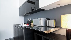 A modern kitchen with a microwave, toaster, and kettle on a black countertop.