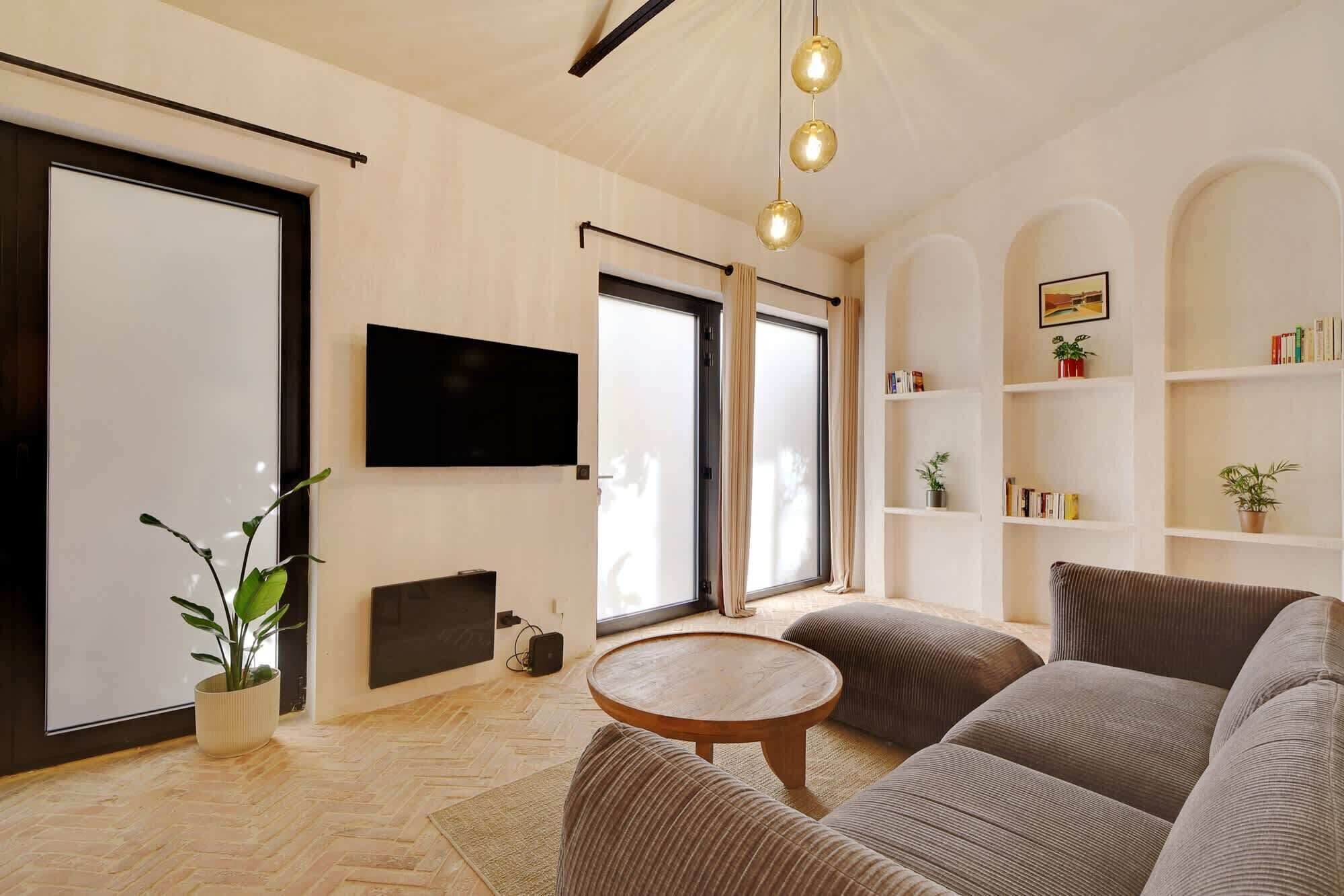 Ein Wohnzimmer mit einer Sofagarnitur, einem Fernseher, einem Kamin und einem Bücherregal.