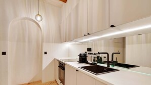 A modern kitchen with a built-in oven, a sink, and a coffee machine. - A Authentic 3-BR/2Ba in Opera - Grands Boulevards (Paris)