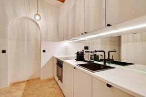 A modern kitchen with a built-in oven, a sink, and a coffee machine. - A Authentic 3-BR/2Ba in Opera - Grands Boulevards (Paris)