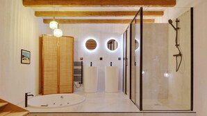 A modern bathroom with a glass-enclosed shower, a freestanding bathtub, and a large mirror. - A Authentic 3-BR/2Ba in Opera - Grands Boulevards (Paris)