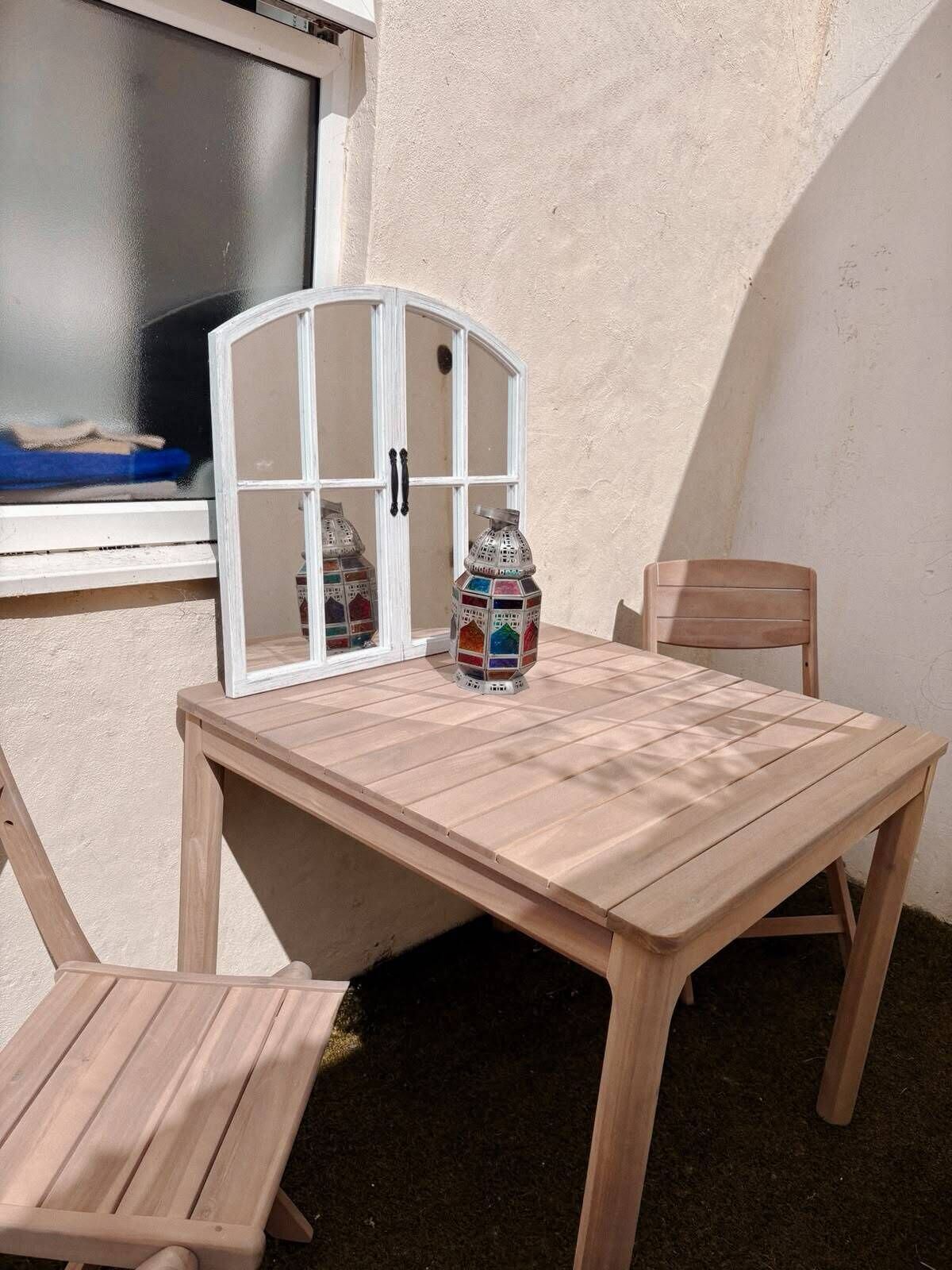 Ein Holztisch mit einer Glasvitrine und einer dekorativen Flasche.