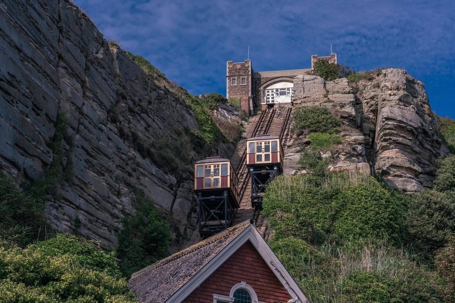 Un edificio al pie de la montaña con una escalera empinada que conduce a una entrada amplia.