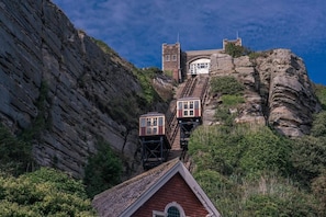Un edificio al pie de la montaña con una escalera empinada que conduce a una entrada amplia.