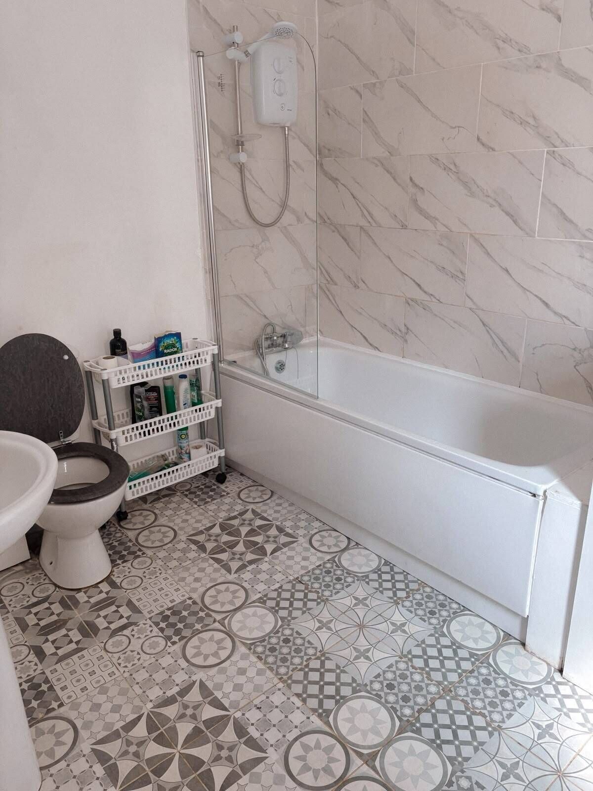 Un baño con bañera, inodoro y ducha.