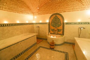 Ein Badezimmer mit Badewanne, Dusche und einer dekorativen Fliesenwand.