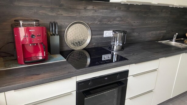 A modern kitchen with a coffee maker, blender, and built-in oven. - Apartment Fein with Wi-Fi in the Heart of the Harz (Bad Sachsa)
