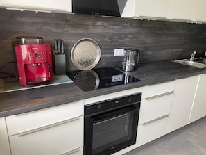Cafetera o tetera, frigorífico, horno y placa de cocina