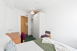 A hotel room with a bed, a desk, a chair, a wardrobe, and a bathroom. - Kings Residence 7 | By My Getaways (Brighton)