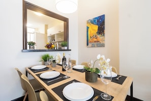A dining area with a long table set for four, a mirror above, and a painting on the wall. - 3 Quartos a 100m da Praia com AC  (Rio de Janeiro)