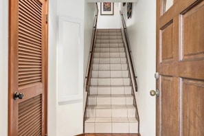 A wooden staircase with a handrail, leading to a white door with a keyhole. - New Listing, Kanaloa, Golf Course Views, AC (Kailua-Kona)