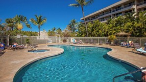 A swimming pool with multiple lanes, surrounded by palm trees and lounge chairs. - Maui Banyan H502 Renovated Partial Ocean View Condo Near Kamaole Beach II (Kihei)