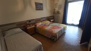 A bedroom with a bed, a nightstand, a dresser, and a window with curtains. - Casa Stella Terminal (Perosa Argentina)