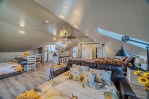 Un loft spacieux avec de hauts plafonds, un coin repas, une cuisine et un coin salon confortable avec un canapé et un lit.