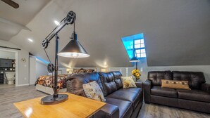 A spacious living room with a large leather sofa, a wooden coffee table, and a modern floor lamp.