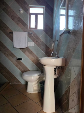 Un baño con inodoro, lavabo y ventana.