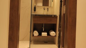 Ein Badezimmer mit einem Holzwaschtisch, einem Spiegel und einem Handtuchhalter.