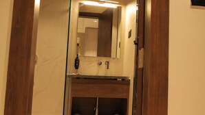 Ein Badezimmer mit einem Holzwaschtisch, einem Spiegel und einem Handtuchhalter.