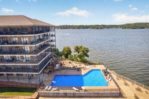 Ein Hotel mit Schwimmbad, Sitzgelegenheiten im Freien und Seeblick.
