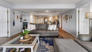 Un salon avec un canapé gris, une table basse et un tapis bleu à motifs.