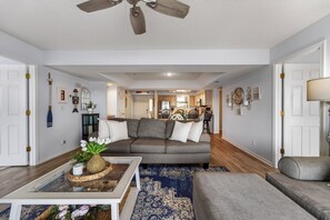 Ein Wohnzimmer mit grauem Sofa, Couchtisch und Teppich mit blauem Muster.