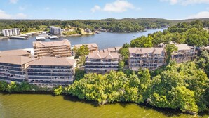 Un hôtel situé au bord de l’eau, composé de plusieurs bâtiments, avec un quai et un lac.