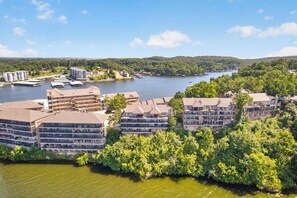 Ein Hotel am Ufer mit mehreren Gebäuden, einem Steg und einem See.