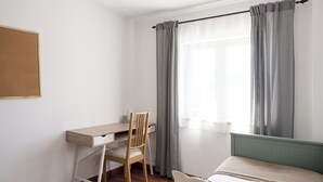 A bedroom with a bed, a desk, and a chair. - Lisbon Olivais Residence – 2BR Apartment (Lisbon)
