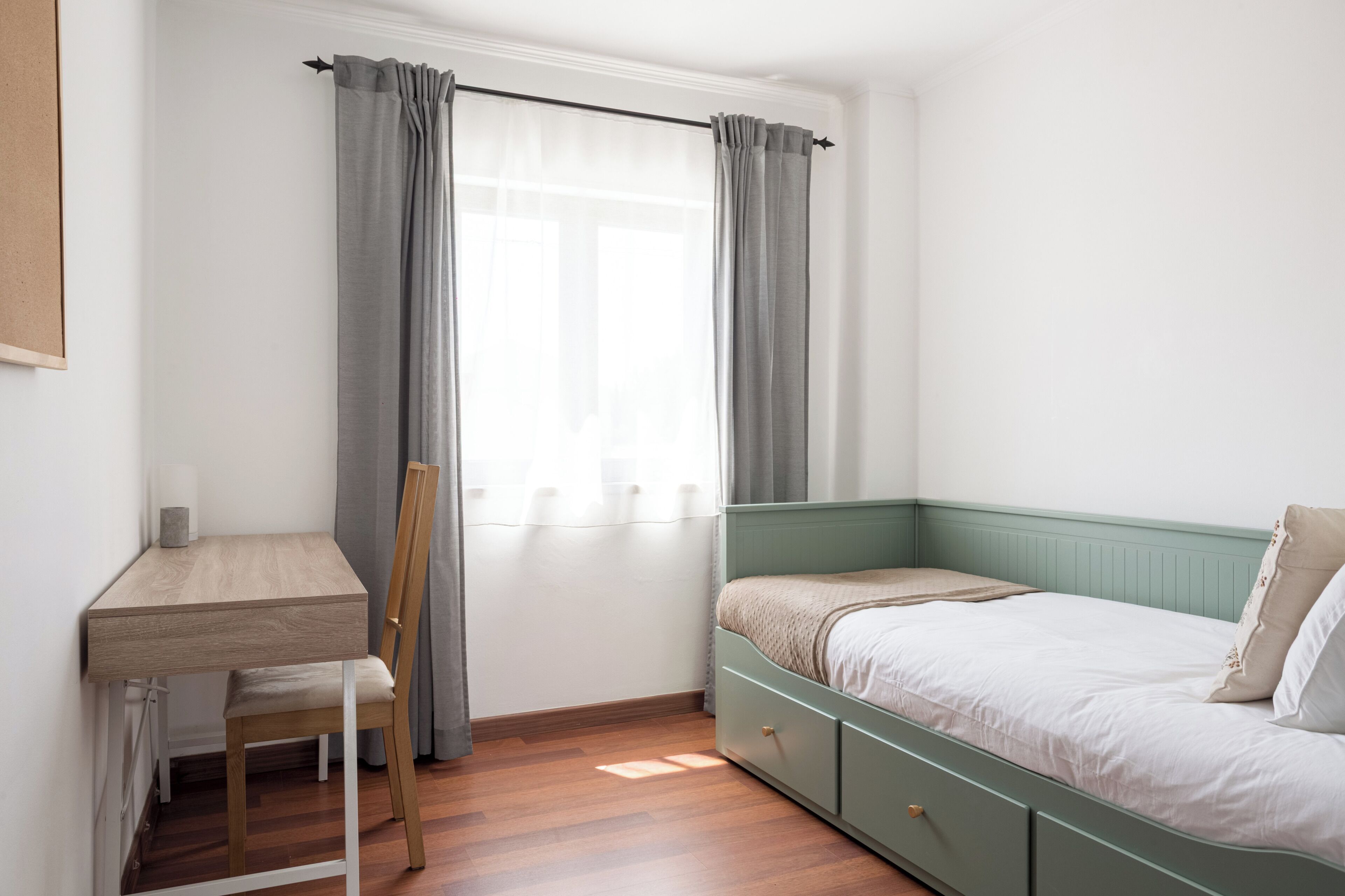 Ein Schlafzimmer mit Bett, Schreibtisch und Stuhl.