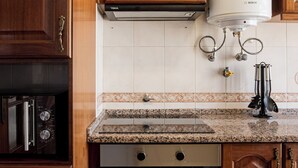 A kitchen with wooden cabinets, a Bosch water heater, a dishwasher, and a granite countertop. - Lisbon Olivais Residence – 2BR Apartment (Lisbon)