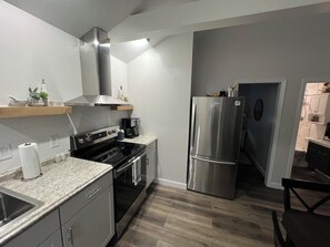 A modern kitchen with stainless steel appliances, a built-in oven, and a coffee maker. - Couples Escape w/ Hot Tub & Fire Pit Near the Lake (Clarklake)