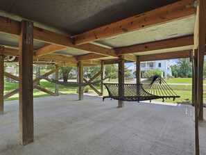 A covered outdoor area with a hammock, wooden beams, and a concrete floor. - Sunny Days - Access The Masonboro Sound (Wilmington)