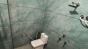 Uma casa de banho com sanita, bidé e zona de duche.