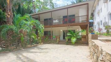 A two-story building with a balcony and a covered patio area.